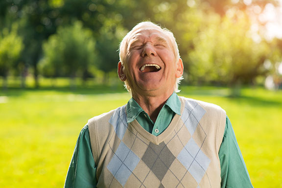 elderly man laughing in park