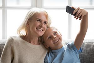 woman with grandson smiling while taking a selfie